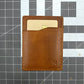 Brown leather wallet with a card on a grid background